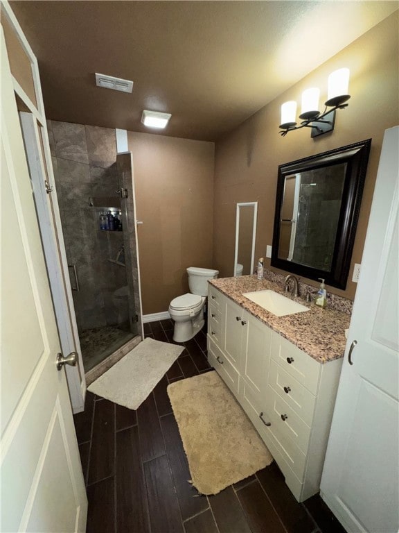 bathroom with vanity, toilet, and a shower with shower door