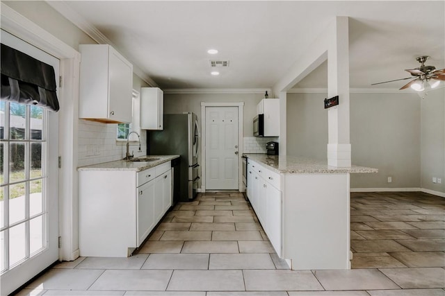 433 Pleiades Pl, Corpus Christi, TX 78418 - kitchen featuring stainless steel appliances, a peninsula, tasteful backsplash, ornamental molding, and white cabinetry
