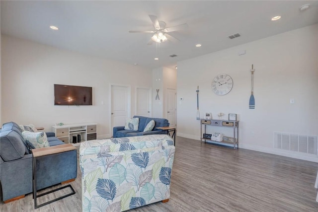 living room with wood-type flooring and ceiling fan