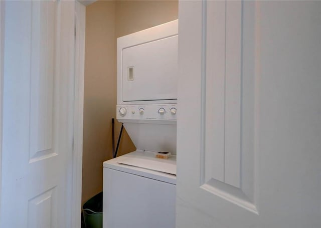 clothes washing area with stacked washer and clothes dryer