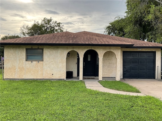 view of front of property with a garage and a front lawn