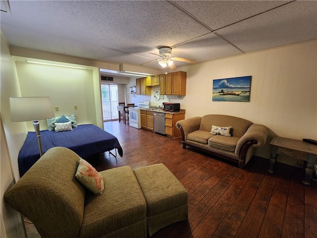 living room featuring ceiling fan and dark wood-type flooring