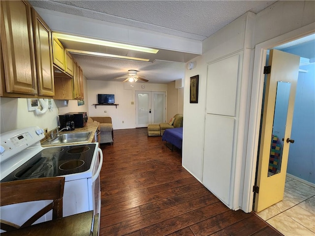 kitchen featuring sink, a textured ceiling, hardwood / wood-style floors, ceiling fan, and white electric range