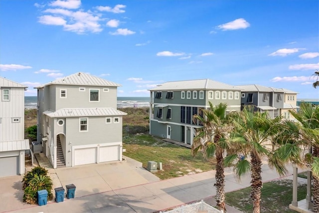 969 Banyan Beach Dr, Port Aransas, TX 78373 - view of front of home with a garage, a water view, concrete driveway, and metal roof
