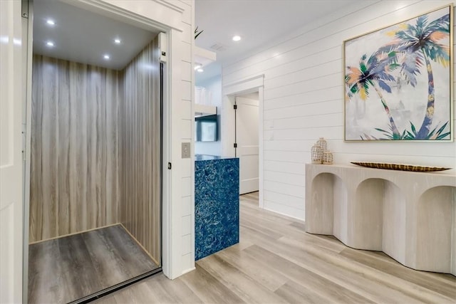 969 Banyan Beach Dr, Port Aransas, TX 78373 - hall featuring elevator, light wood-type flooring, wood walls, and recessed lighting