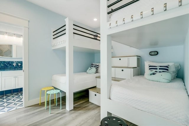 969 Banyan Beach Dr, Port Aransas, TX 78373 - bedroom with wood finished floors, ensuite bathroom, and baseboards