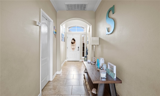 doorway featuring ornamental molding and light tile patterned flooring