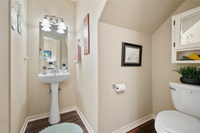 half bathroom with toilet, baseboards, and wood finished floors