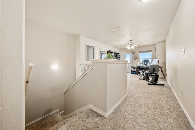 corridor featuring carpet floors, an upstairs landing, and baseboards