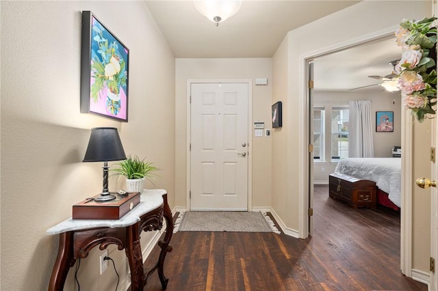 entryway featuring dark wood-style floors, ceiling fan, and baseboards