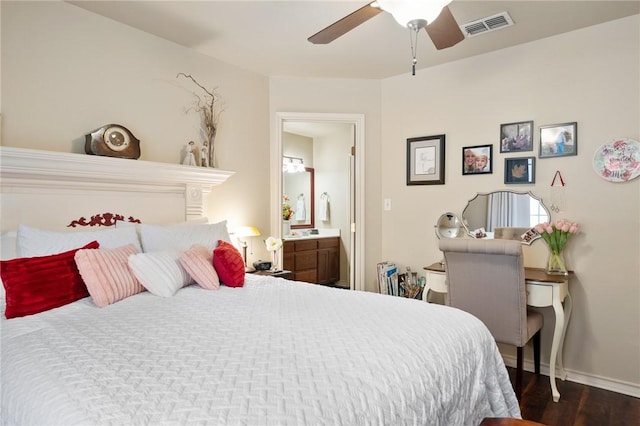 bedroom featuring dark wood finished floors, visible vents, ensuite bathroom, ceiling fan, and baseboards