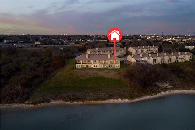 aerial view at dusk featuring a water view