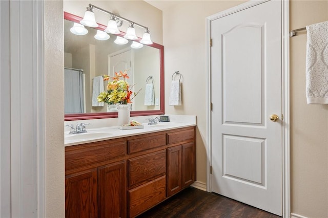 full bath with wood finished floors, a sink, and double vanity