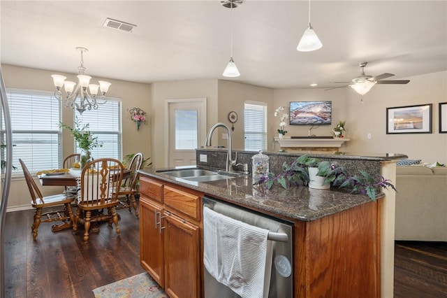 kitchen featuring dark wood-style floors, a sink, visible vents, brown cabinets, and dishwasher