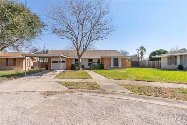 ranch-style house featuring brick siding, fence, concrete driveway, a carport, and a front yard