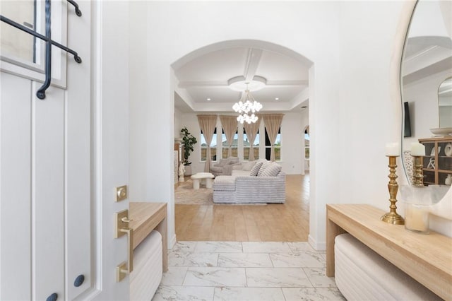 interior space featuring light wood-type flooring, a tray ceiling, and an inviting chandelier