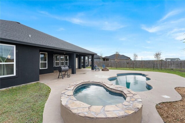 view of swimming pool featuring a hot tub and a patio area