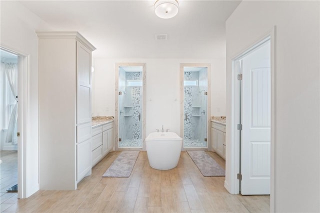 bathroom with wood-type flooring, vanity, and separate shower and tub