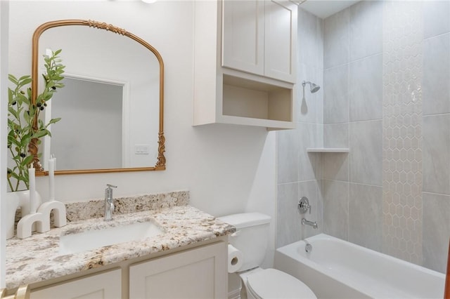 full bathroom with tiled shower / bath, vanity, and toilet