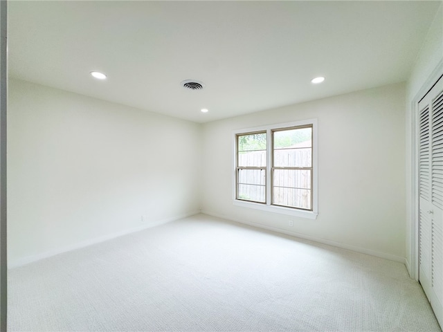 unfurnished bedroom featuring a closet and light carpet