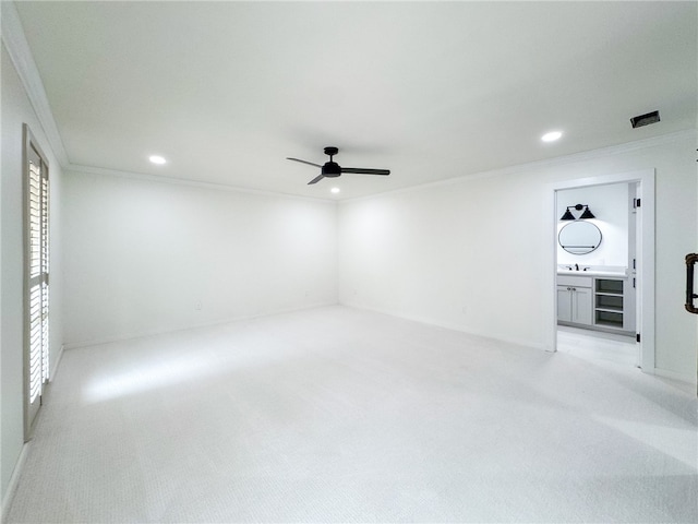 carpeted spare room featuring wine cooler, ceiling fan, crown molding, and sink