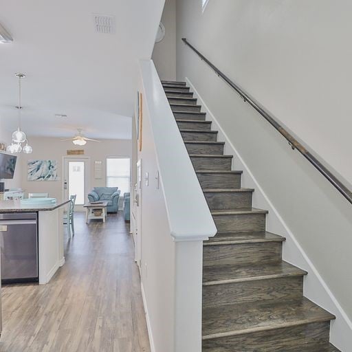 staircase featuring hardwood / wood-style flooring and ceiling fan