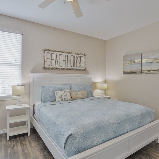 bedroom featuring ceiling fan, multiple windows, and dark hardwood / wood-style flooring