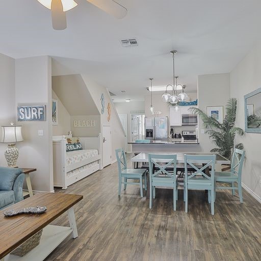 dining area featuring dark hardwood / wood-style floors and ceiling fan with notable chandelier