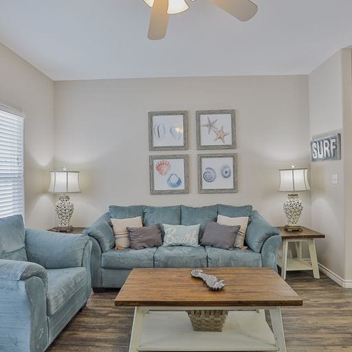 living room with dark wood-type flooring and ceiling fan