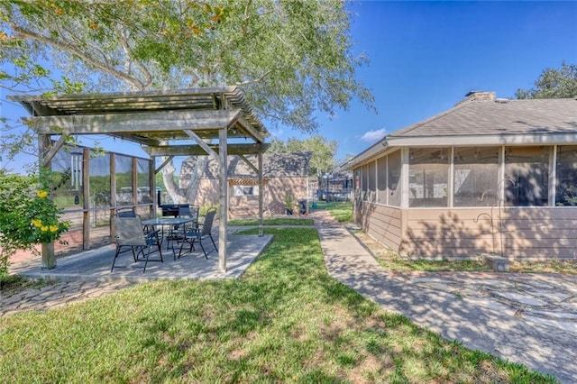 view of yard with a patio, a sunroom, and a pergola