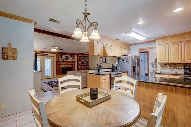 dining space featuring light tile patterned flooring, ceiling fan with notable chandelier, and ornamental molding