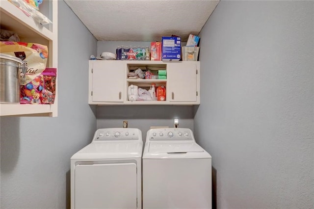 laundry area featuring independent washer and dryer, cabinets, and a textured ceiling