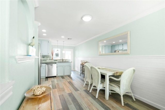 604 Beach Access Road 1a 9-B, Port Aransas, TX 78373 - dining space featuring ornamental molding, light wood-style floors, a wainscoted wall, and recessed lighting
