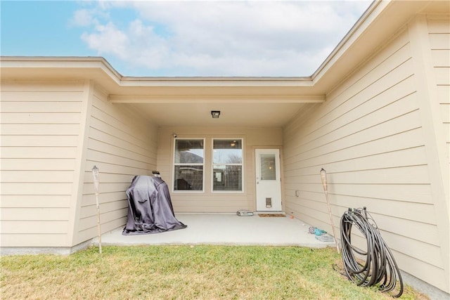 property entrance featuring a yard and a patio area