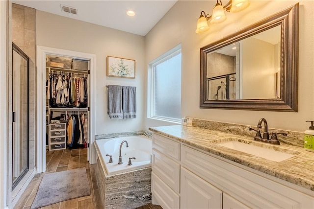 bathroom featuring vanity and separate shower and tub