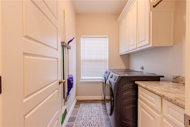 clothes washing area featuring cabinets and separate washer and dryer