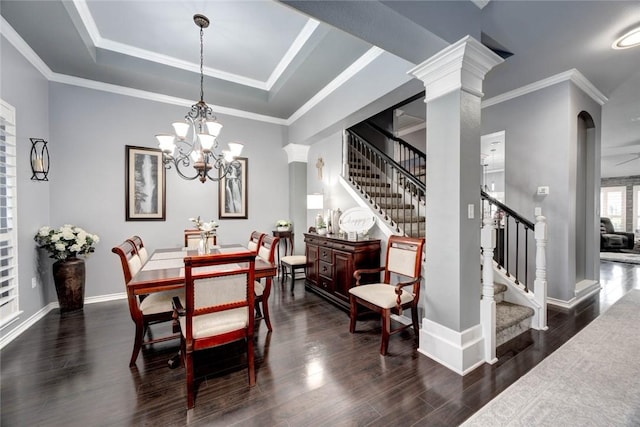 dining space featuring a tray ceiling, dark wood-style flooring, ornamental molding, baseboards, and stairs