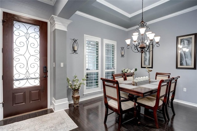 dining room with dark wood-type flooring, baseboards, ornamental molding, a raised ceiling, and decorative columns