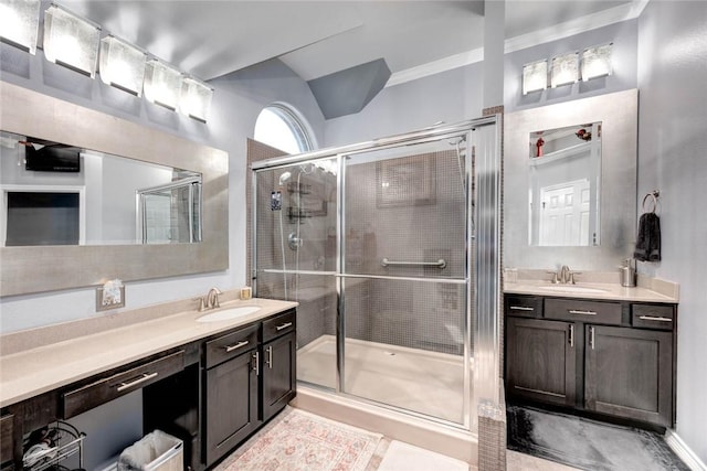 full bathroom featuring a stall shower, two vanities, and a sink