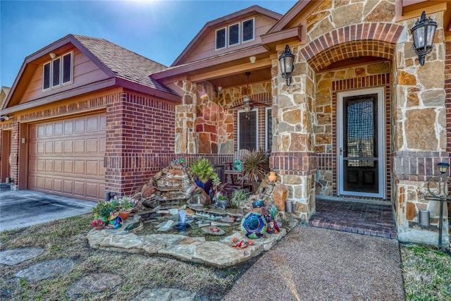 view of exterior entry with stone siding, brick siding, and roof with shingles