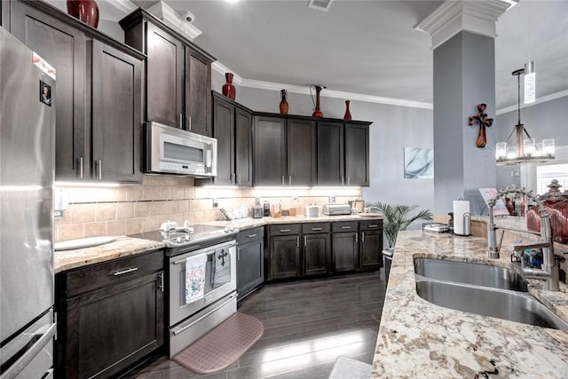 kitchen featuring dark brown cabinetry, a sink, appliances with stainless steel finishes, decorative backsplash, and crown molding