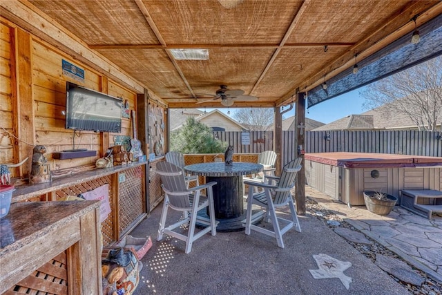 view of patio with a hot tub, ceiling fan, and outdoor dining space