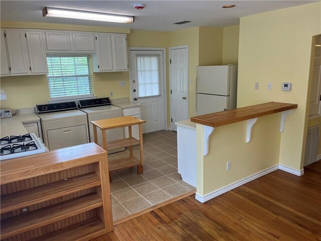 822 Indiana Ave, Corpus Christi, TX 78404 - kitchen featuring washer and dryer, visible vents, light countertops, and freestanding refrigerator
