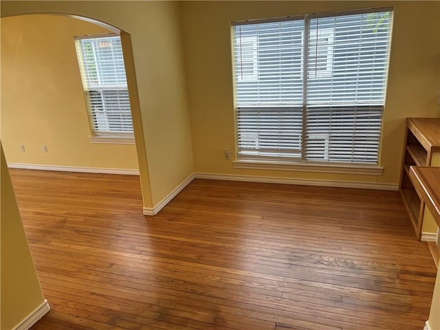 822 Indiana Ave, Corpus Christi, TX 78404 - empty room featuring wood-type flooring, arched walkways, and baseboards