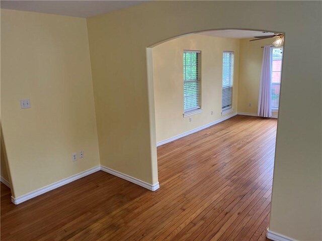 822 Indiana Ave, Corpus Christi, TX 78404 - unfurnished room with arched walkways, ceiling fan, baseboards, and hardwood / wood-style floors