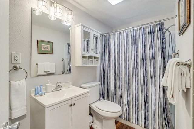 bathroom featuring hardwood / wood-style flooring, vanity, curtained shower, and toilet