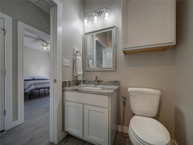 bathroom with toilet, wood finished floors, a ceiling fan, and vanity