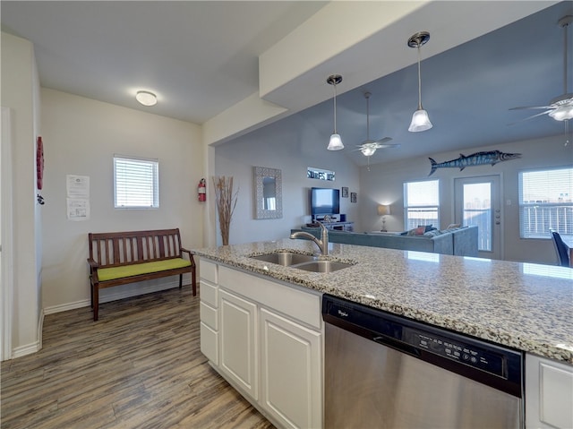 kitchen with wood-type flooring, pendant lighting, sink, stainless steel dishwasher, and white cabinetry