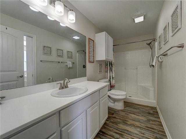 bathroom with hardwood / wood-style flooring, vanity, curtained shower, and toilet