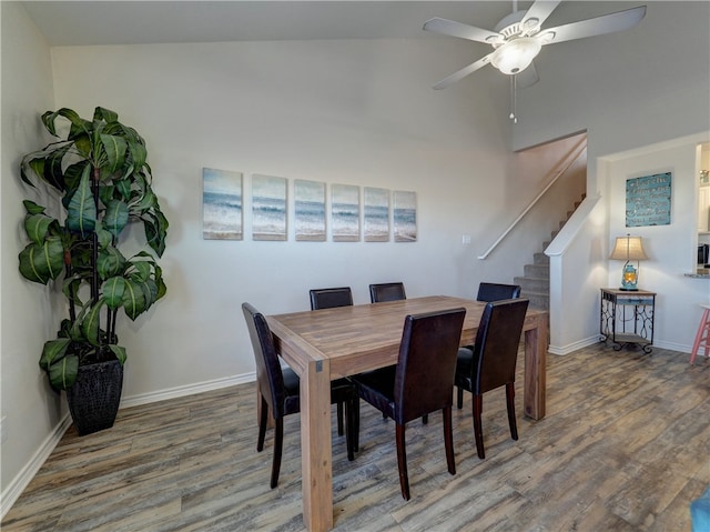 dining space featuring high vaulted ceiling, hardwood / wood-style floors, and ceiling fan